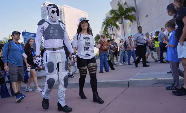Chris Lane, left, and his wife Shannon, wearing costumes inspired by the Apple TV+ series "Murderbot," walk through the crowd before the 2025 Comic-Con International Preview Night on Wednesday, July 23, 2025, in San Diego. (AP Photo/Chris Pizzello)