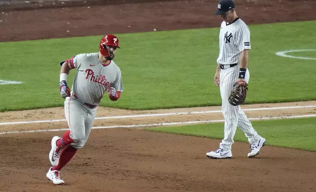 New York Yankees first base Paul Goldschmidt, right, reacts as Philadelphia Phillies' Kyle Schwarberruns the bases after hitting a two-run home run during the eighth inning of a baseball game Friday, July 25, 2025, in New York. (AP Photo/Frank Franklin II)