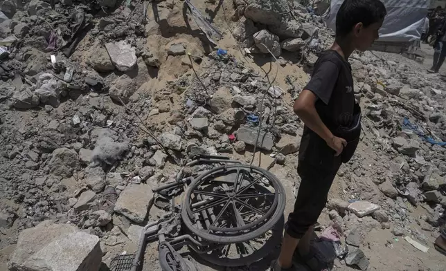 A kid stands next to the rubbles following an Israeli strike on tents sheltering displaced Palestinians in Gaza City on Tuesday, July 8, 2025. (AP Photo/Jehad Alshrafi)