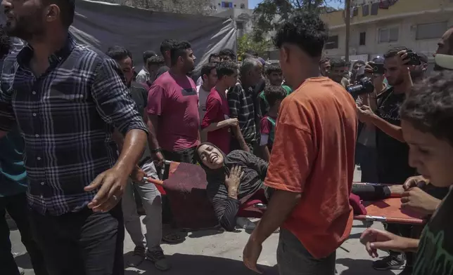 A woman is evacuated after an Israeli strike on tents sheltering displaced Palestinians in Gaza City on Tuesday, July 8, 2025. (AP Photo/Jehad Alshrafi)