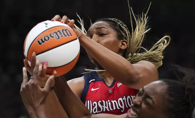 Washington Mystics forward Kiki Iriafen, top, vies for the rebound against Seattle Storm forward Nneka Ogwumike, bottom, during the second half of a WNBA basketball game Sunday, July 13, 2025, in Seattle. (AP Photo/Lindsey Wasson)