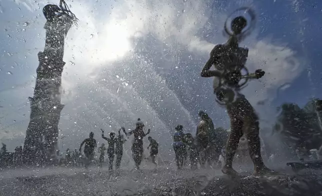 Children run in a fountain in St. Petersburg, Russia, Saturday, July 12, 2025. (AP Photo/Dmitri Lovetsky)