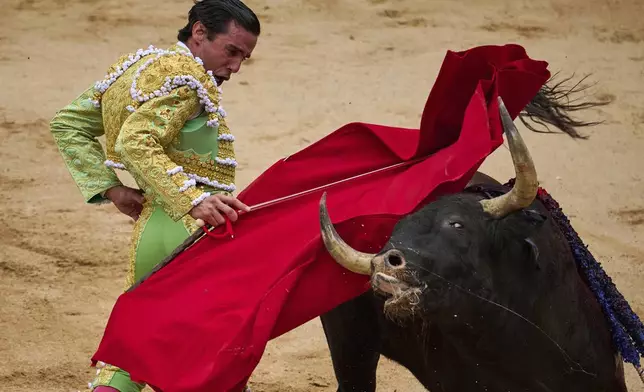 Spanish bullfighter Juan Ortega performs during a bullfight at the San Fermin Festival in Pamplona, northern Spain, Friday, July 11, 2025. (AP Photo/Miguel Oses)