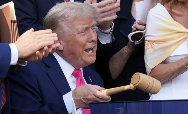 President Donald Trump bangs a gavel after signing his signature bill of tax breaks and spending cuts at the White House in Washington, Friday, July 4, 2025.(AP Photo/Alex Brandon, Pool)