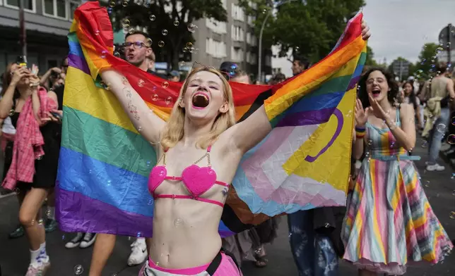 People dance as they take part in the LGBTQ annual pride march in Berlin, Germany, Saturday, July 26, 2025. (AP Photo/Ebrahim Noroozi)