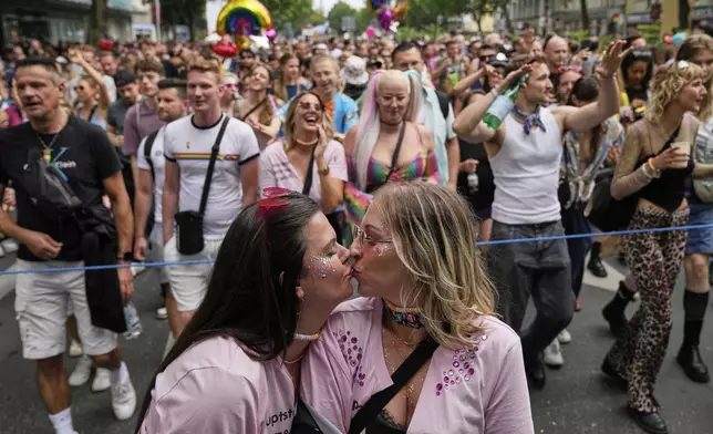 Two women kiss as they take part in the LGBTQ annual pride march in Berlin, Germany, Saturday, July 26, 2025. (AP Photo/Ebrahim Noroozi)