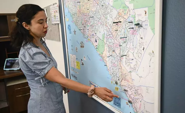 Megan Tambio, community engagement manager for the Friendship Shelter, points out the units in Orange County that the organization provides for homeless people during a tour of the organization's headquarters Monday, July 7, 2025, in San Clemente, Calif. (AP Photo/Denis Poroy)
