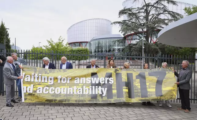 People demonstrate outside the European Court of Human Rights before it issues a landmark set of rulings about alleged Russian violations in Ukraine since 2014, including the downing of Malaysia Airlines flight MH17, Wednesday, July 9, 2025 in Strasbourg, eastern France. (AP Photo/Antonin Utz)