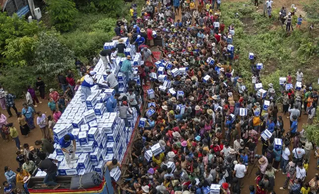 Displaced Cambodians receive water at the Battkhao Resettlement Camp in Oddar Meanchey Province, Cambodia, Saturday, July 26, 2025 as border clashes between Thailand and Cambodia entered its third day. (AP Photo/Anton L. Delgado)