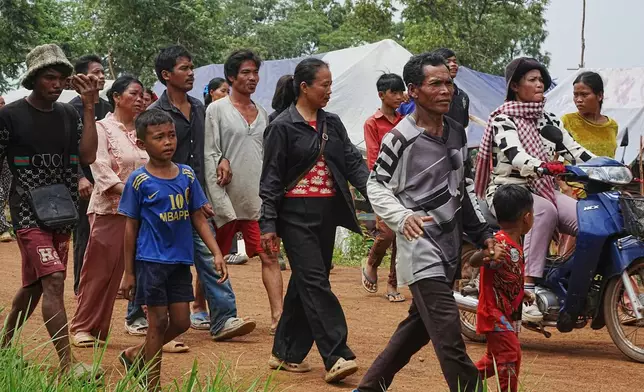 Cambodian villagers head to receive drinking water donated by a local company as they take refuge in Batthkoa primary school in Oddar Meanchey province, Cambodia, Saturday, July 26, 2025, as border fighting between Thailand and Cambodia entered its third day. (AP Photo/Heng Sinith)