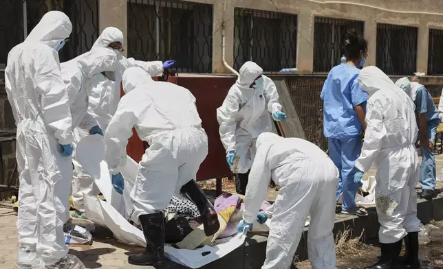 Morgue workers place the bodies of unidentified people killed during clashes between Bedouin clans and Druze militias, into plastic bags outside the National Hospital in Sweida, Syria, Monday, July 21, 2025. (AP Photo/Fahd Kiwan)