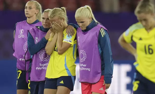 Sweden's Smilla Holmberg, 3rd left, is conforted by her teammates after missing the decisive penalty in a penalty shootout at the end of the Women's Euro 2025 quarterfinals soccer match between Sweden and England at Stadion Letzigrund in Zurich, Switzerland, Thursday, July 17, 2025. (AP Photo/Alessandra Tarantino)