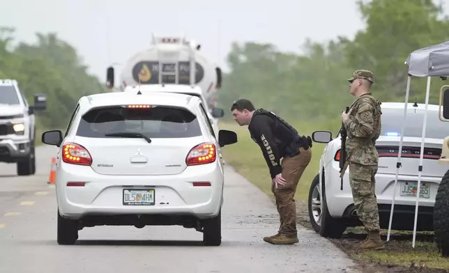 Police check cars arriving at the "Alligator Alcatraz," a new migrant detention facility at the Dade-Collier Training and Transition facility, Wednesday, July 2, 2025, in Ochopee, Fla. (AP Photo/Marta Lavandier)