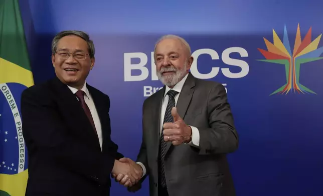 Brazilian President Luiz Inacio Lula da Silva, right, flashes a thumbs up as he and China's Premier Li Qiang pose for photos during their bilateral meeting ahead of the upcoming 17th annual BRICS summit in Rio de Janeiro, Saturday, July 5, 2025. (AP Photo/Bruna Prado)