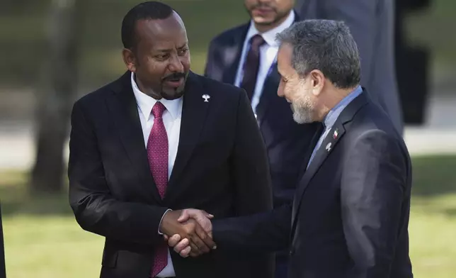 Prime Minister of Ethiopia Abiy Ahmed, left, shakes hands with Iranian Foreign Minister Abbas Araghchi during the 17th annual BRICS summit in Rio de Janeiro, Sunday, July 6, 2025. (AP Photo/Silvia Izquierdo)