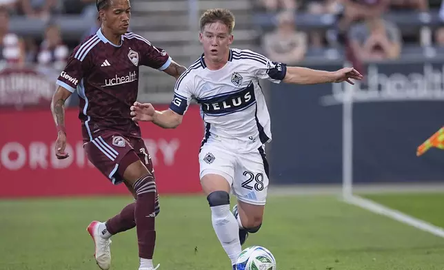 Vancouver Whitecaps defender Tate Johnson, right, drives past Colorado Rapids forward Calvin Harris, left, in the first half of an MLS soccer match Saturday, July 12, 2025, in Commerce City, Colo. (AP Photo/David Zalubowski)