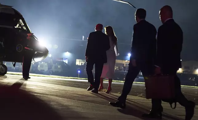 President Donald Trump and first lady Melania Trump, center, walk to Marine One after departing Air Force One at Morristown Municipal Airport in Morristown, N.J., Friday, July 4, 2025, en route to Bedminster. (AP Photo/Jacquelyn Martin)