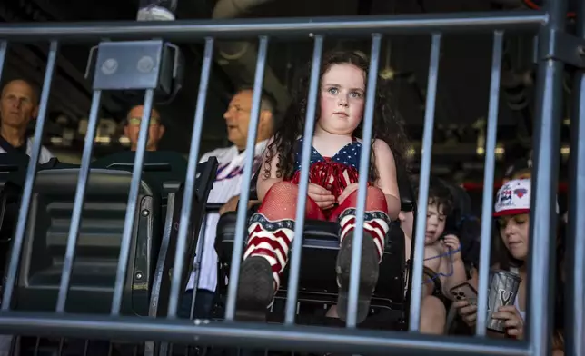 Johan McDonalds, dressed in an American flag-inspired Fourth of July outfit, watches the baseball game between the New York Yankees and the New York Mets, Friday, July 4, 2025, in New York. (AP Photo/Angelina Katsanis)