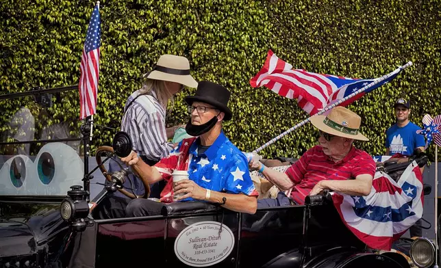 Participants in an antique car prepare to take part in the Independence Day Parade in Santa Monica, Calif. on Friday, July 4, 2025. (AP Photo/Richard Vogel)