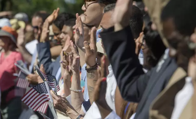 People stand and take the Naturalization Oath of Allegiance on Independence Day at George Washington's Mount Vernon, Friday, July 4, 2025, in Alexandria, Va. (AP Photo/Rod Lamkey, Jr.)
