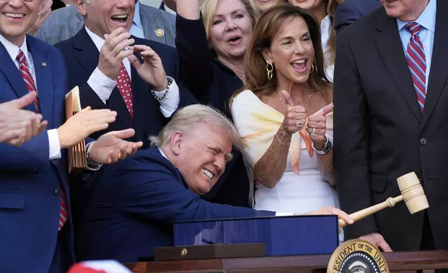 President Donald Trump bangs a gavel after signing his signature bill of tax breaks and spending cuts at the White House in Washington, Friday, July 4, 2025.(AP Photo/Alex Brandon, Pool)