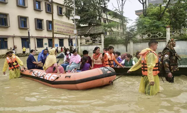 FILE - Army soldiers and rescuers evacuate patients and medical staff from a flooded hospital following landslides and flash flooding amid monsoon season in Imphal, India, June 1, 2025. (AP Photo/Donald Sairem, File)