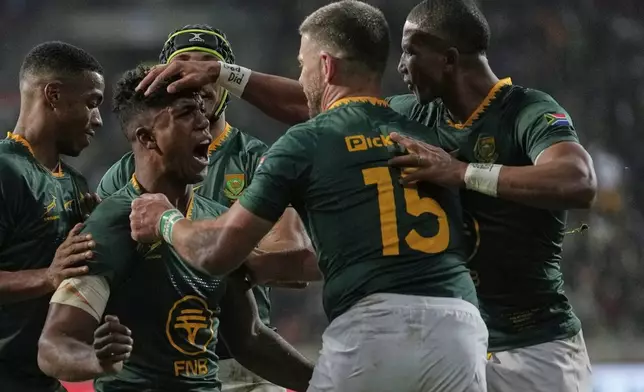 South Africa's Canan Moodie, left, celebrates with teammates after scoring a try during a rugby championship test match between South Africa and Italy, at the Nelson Mandela Bay stadium in Gqeberha, South Africa, Saturday, July 12, 2025. (AP Photo/Themba Hadebe)