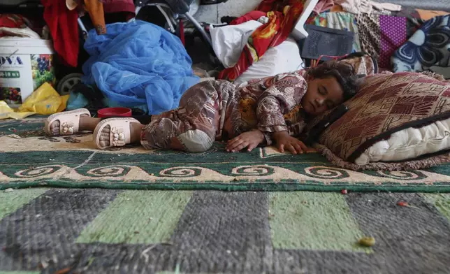A displaced Bedouin girl sleeps inside a shelter after her family fled their home due to clashes between Bedouin clans and Druze militias, in Busra al-Harir village, southern Syria, Sunday, July 20, 2025. (AP Photo/Omar Sanadiki)