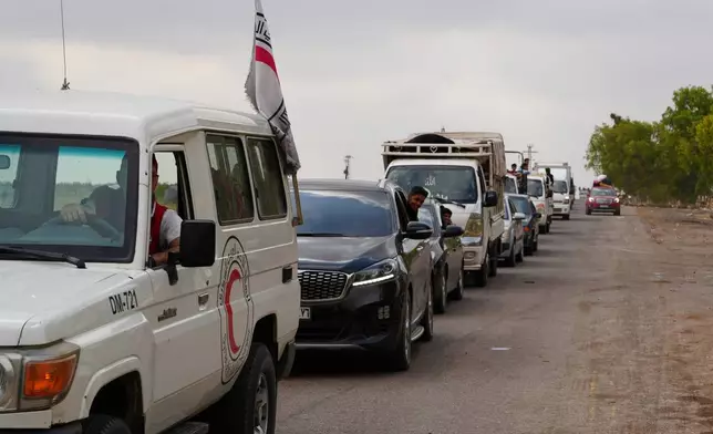 Syrian Bedouin families ride in a convoy led by Red Crescent vehicles in Busra al-Harir, heading to Daraa after being evacuated from Sweida following more than a week of violent clashes, Monday, July 21, 2025. (AP Photo/Malek Khattab)