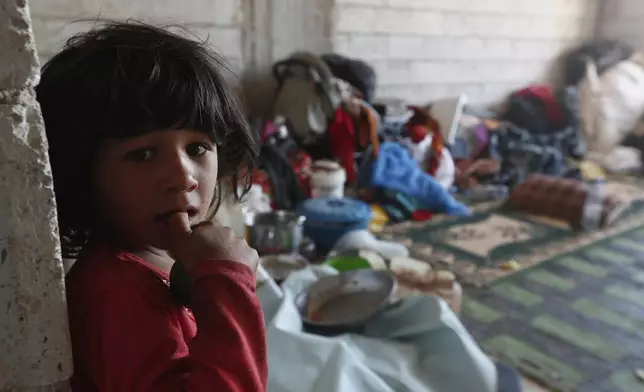 A displaced Bedouin girl stands inside a shelter after her family fled their home due to clashes between Bedouin clans and Druze militias, in Busra al-Harir village, southern Syria, Sunday, July 20, 2025. (AP Photo/Omar Sanadiki)