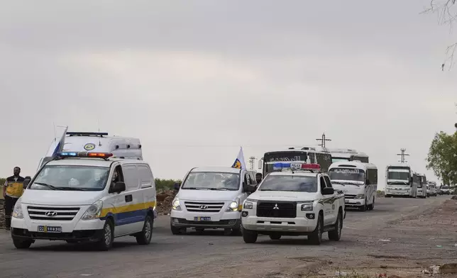 Syrian Bedouin families ride in a convoy led by Red Crescent vehicles in Busra al-Harir, heading to Daraa after being evacuated from Sweida following more than a week of violent clashes, Monday, July 21, 2025. (AP Photo/Malek Khattab)