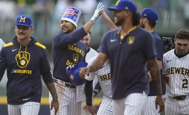 Milwaukee Brewers' Blake Perkins, second from left, is congratulated by teammates after hitting a walkoff RBI single during the ninth inning of a baseball game against the Miami Marlins, Sunday, July 27, 2025, in Milwaukee. (AP Photo/Aaron Gash)