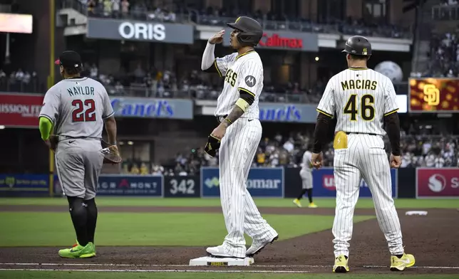San Diego Padres' Manny Machado, center, reacts after hitting a single, his 2000th career hit, during the fourth inning of a baseball game against the Arizona Diamondbacks, Monday, July 7, 2025, in San Diego. (AP Photo/Orlando Ramirez)