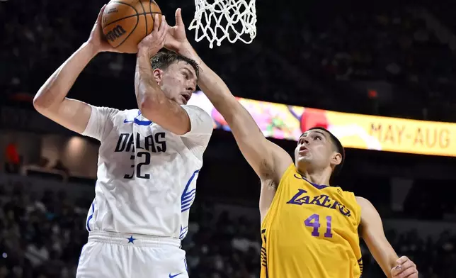 Dallas Mavericks forward Cooper Flagg (32) grabs a rebound against Los Angeles Lakers forward Cole Swider (41) during the first half of an NBA summer league basketball game Thursday, July 10, 2025, in Las Vegas. (AP Photo/David Becker)
