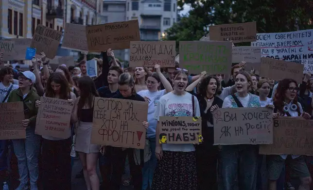 Protestant chant while holding banners that read "I stand for you, and for those who are on the frontline", "Do you want it like in Russia", "Stop robbing our future" during a protest against a law targeting anti-corruption institutions in central Kyiv, Ukraine, Tuesday, July 22, 2025. (AP Photo/Alex Babenko)