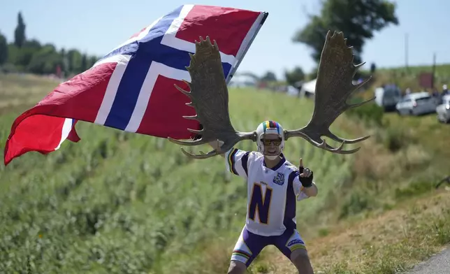 A fan holds a flag of Norway during the eleventh stage of the Tour de France cycling race over 156.8 kilometers (97.4 miles) with start and finish in Toulouse, France, Wednesday, July 16, 2025. (AP Photo/Mosa'ab Elshamy)