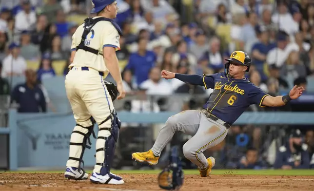 Milwaukee Brewers' Isaac Collins, right, scores on a double by Caleb Durbin as Los Angeles Dodgers catcher Will Smith waits for the ball during the sixth inning of a baseball game Saturday, July 19, 2025, in Los Angeles. (AP Photo/Mark J. Terrill)