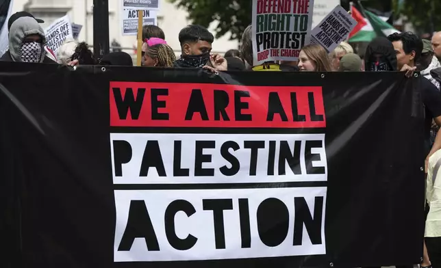 Demonstrators hold up a banner during a protest by Palestine Action group in London, Monday, June 23, 2025. (AP Photo/Frank Augstein)
