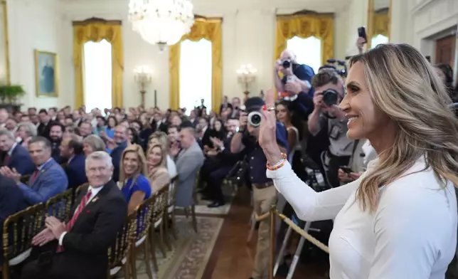 Lara Trump waves to the audience as President Donald Trump speaks at an event for the signing of the GENIUS Act, a bill that regulates stablecoins, a type of cryptocurrency, in the East Room of the White House, Friday, July 18, 2025, in Washington. (AP Photo/Alex Brandon)