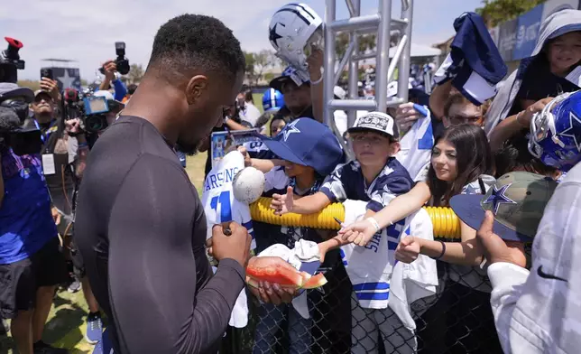 Dallas Cowboys defensive end Micah Parsons signs autographs during training camp Tuesday, July 22, 2025, in Oxnard, Calif. (AP Photo/Mark J. Terrill)