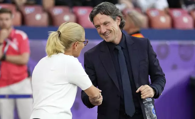 France head coach Laurent Bonadei and England head coach Sarina Wiegman, left, greet each other before the Euro 2025, group D, soccer match between France and England at Stadion Letzigrund in Zurich, Switzerland, Saturday, July 5, 2025. (AP Photo/Martin Meissner)