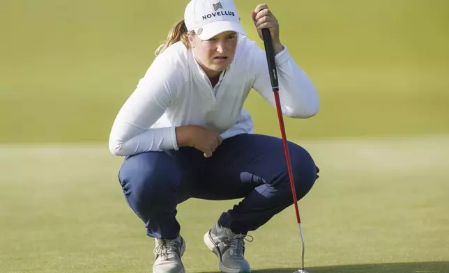 Lottie Woad, of England, looks over her line during the first round of the women's Scottish Open golf tournament, Thursday, July 24, 2025, at Dundonald Links in Irvine, Scotland. (Steve Welsh/PA via AP)