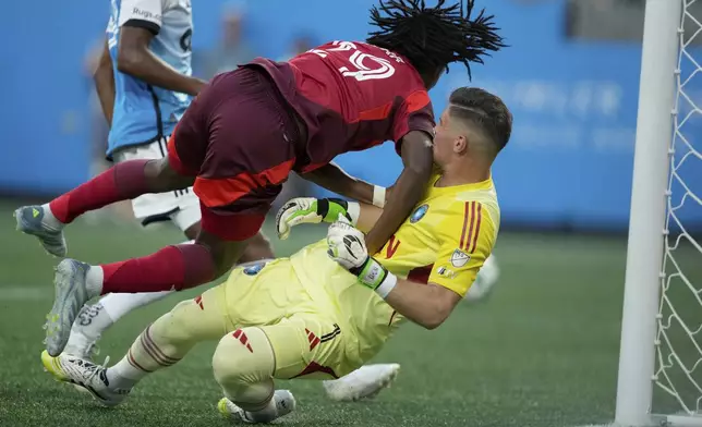 Toronto FC forward Deandre Kerr collides with Charlotte FC goalkeeper Kristijan Kahlina during the first half of a MLS soccer game Saturday, July 26, 2025, in Charlotte, N.C. (AP Photo/Chris Carlson)
