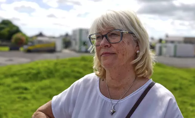 Annette McKay, whose mother gave birth to a baby girl who died at the mother and baby home in Tuam, Ireland, stands next to the area where workers are excavating remains of up to nearly 800 children believed to be buried there, Tuesday, July 8, 2025. (AP Photo/Brian Melley)