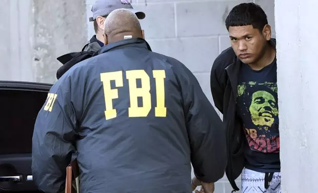 FILE - In this Thursday, March 2, 2017 photo, accused MS-13 gang member Alexi Saenz, is escorted by FBI agents in Central Islip, N.Y., after being taken into custody. (James Carbone/Newsday via AP, File)