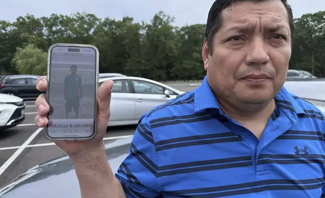 Santos Castillo stands outside federal court in Central Islip, N.Y., on Wednesday, July 2, 2025, holding up a photo on his phone of his son, Javier Castillo, who was slain by MS-13 gang members in 2016. (AP Photo/Philip Marcelo)