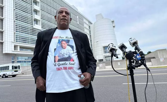 George Johnson stands outside federal court in Central Islip, N.Y. on Wednesday, July 2, 2025 wearing a shirt bearing an image of his son, Michael Johnson, who was slain by MS-13 gang members in 2016. (AP Photo/Philip Marcelo)