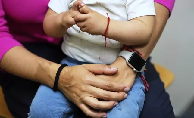 A woman and her 16-month-old son wait to see a doctor at a CommuniCARE+OLE clinic Thursday, June 26, 2025, in Davis, Calif. (AP Photo/Godofredo A. Vásquez)
