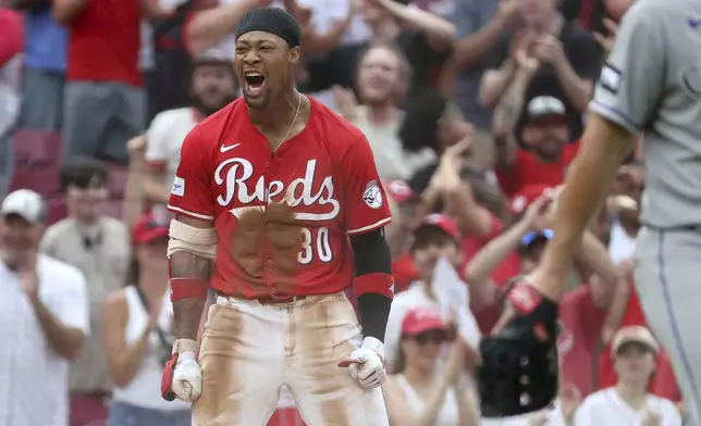 Cincinnati Reds' Will Benson (30) celebrates after hitting an RBI triple during the ninth inning of a baseball game against the Colorado Rockies, Saturday, July 12, 2025, in Cincinnati. (AP Photo/Joe Maiorana)