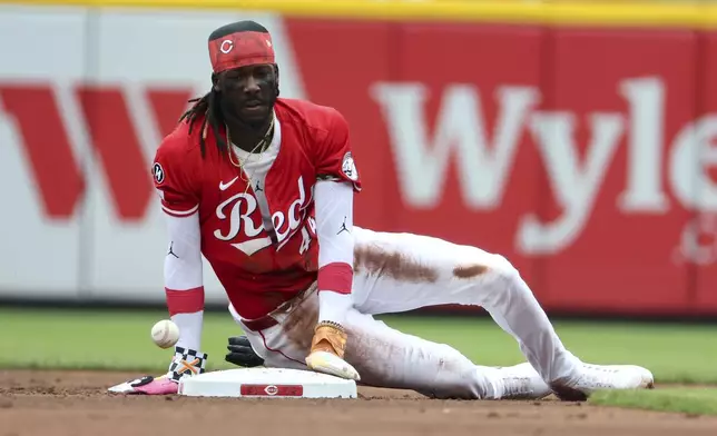 Cincinnati Reds shortstop Elly De La Cruz (44) watches as the ball bounces past on his successful stolen base attempt during the first inning of a baseball game against the Colorado Rockies, Saturday, July 12, 2025, in Cincinnati. (AP Photo/Joe Maiorana)